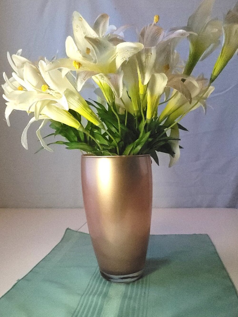 Faux Silk White Easter Lily Arrangement in Metallic Rose Gold Glass Vase